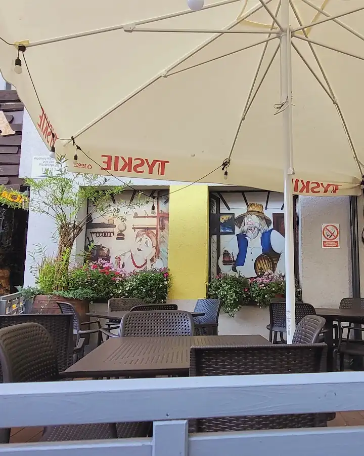 Ogródek Kurnej Chaty pod białymi parasolami